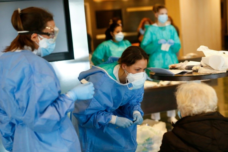 Healthcare workers attend to a COVID-19 patient at Hotel Melia Barcelona Sarria, which has been converted into a hospital, in Barcelona, Spain. /AFP